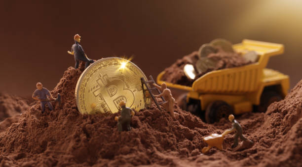 Kiev, Ukraine - June 10, 2021: Miner digging ground to uncover big Gold bitcoin. Cryptocurrency Mining concept